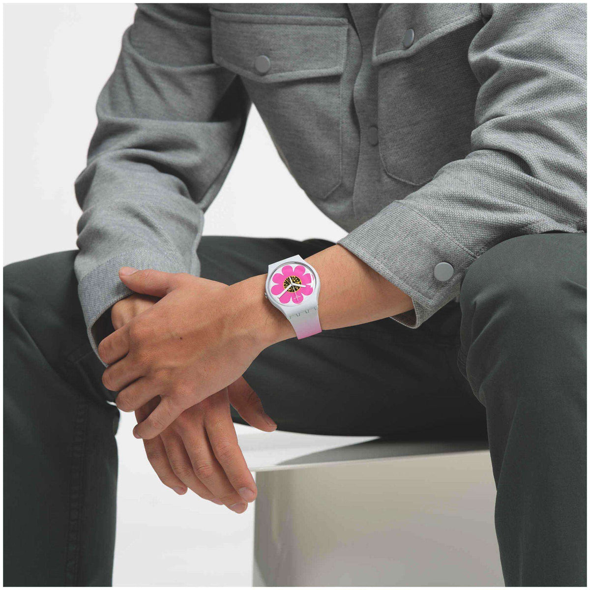 Pink flower dial silicone watch on wrist with long sleeve and clasped hands
