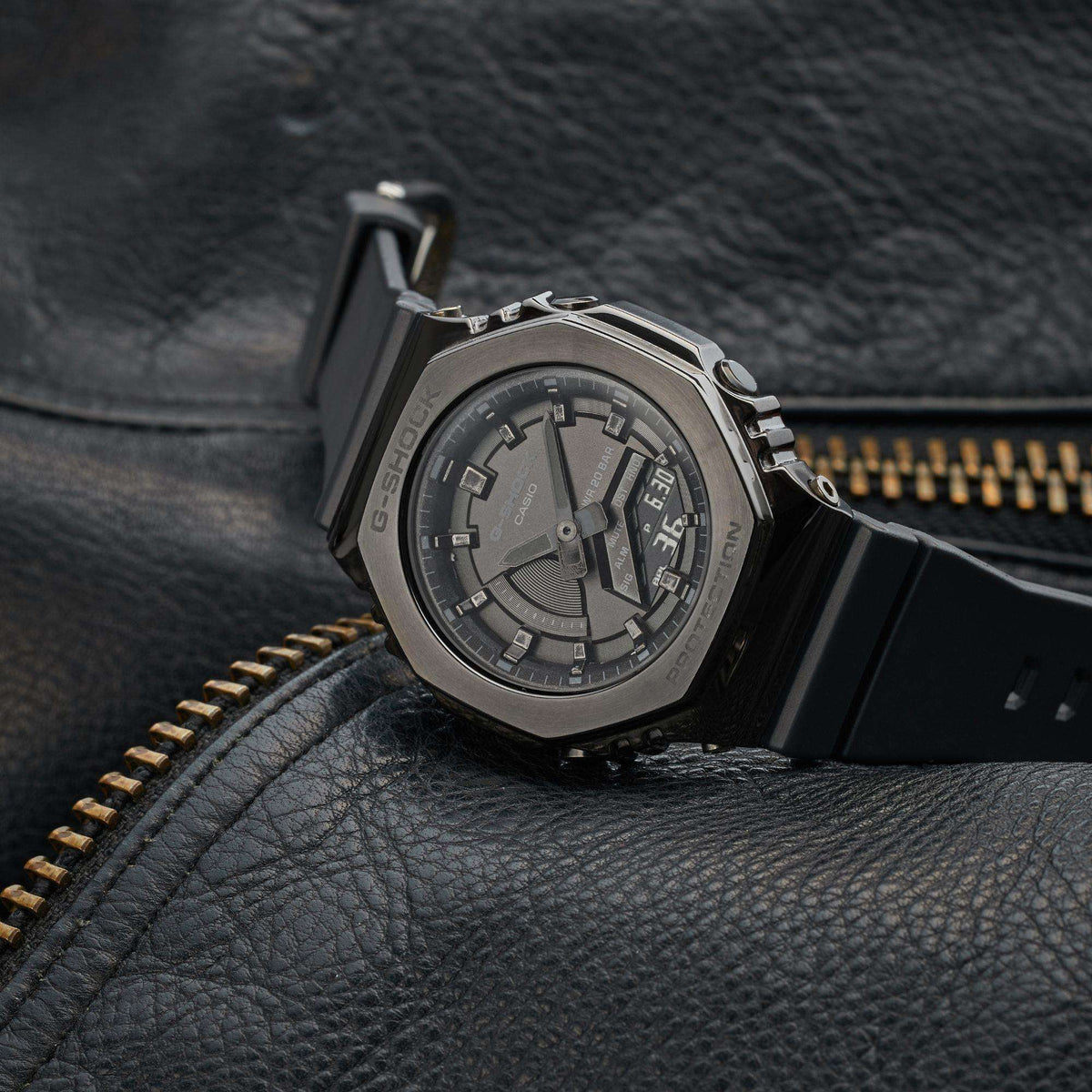 Men's black Casio G-Shock CasiOak watch with metal bezel, leather background close-up