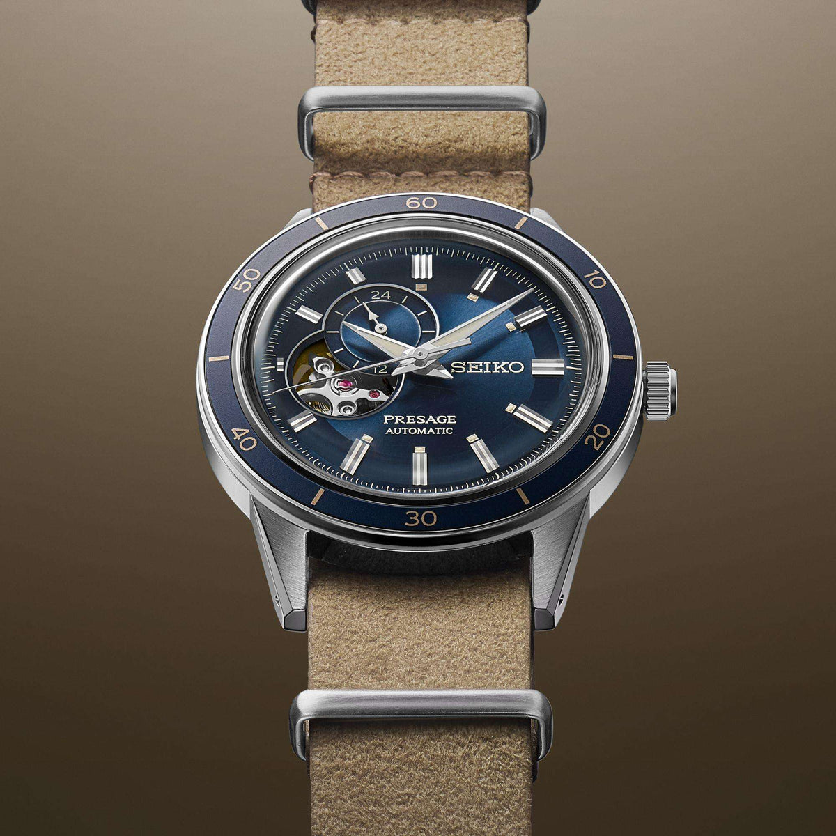 Men’s automatic watch with blue dial, dual-tone bezel, and beige leather strap