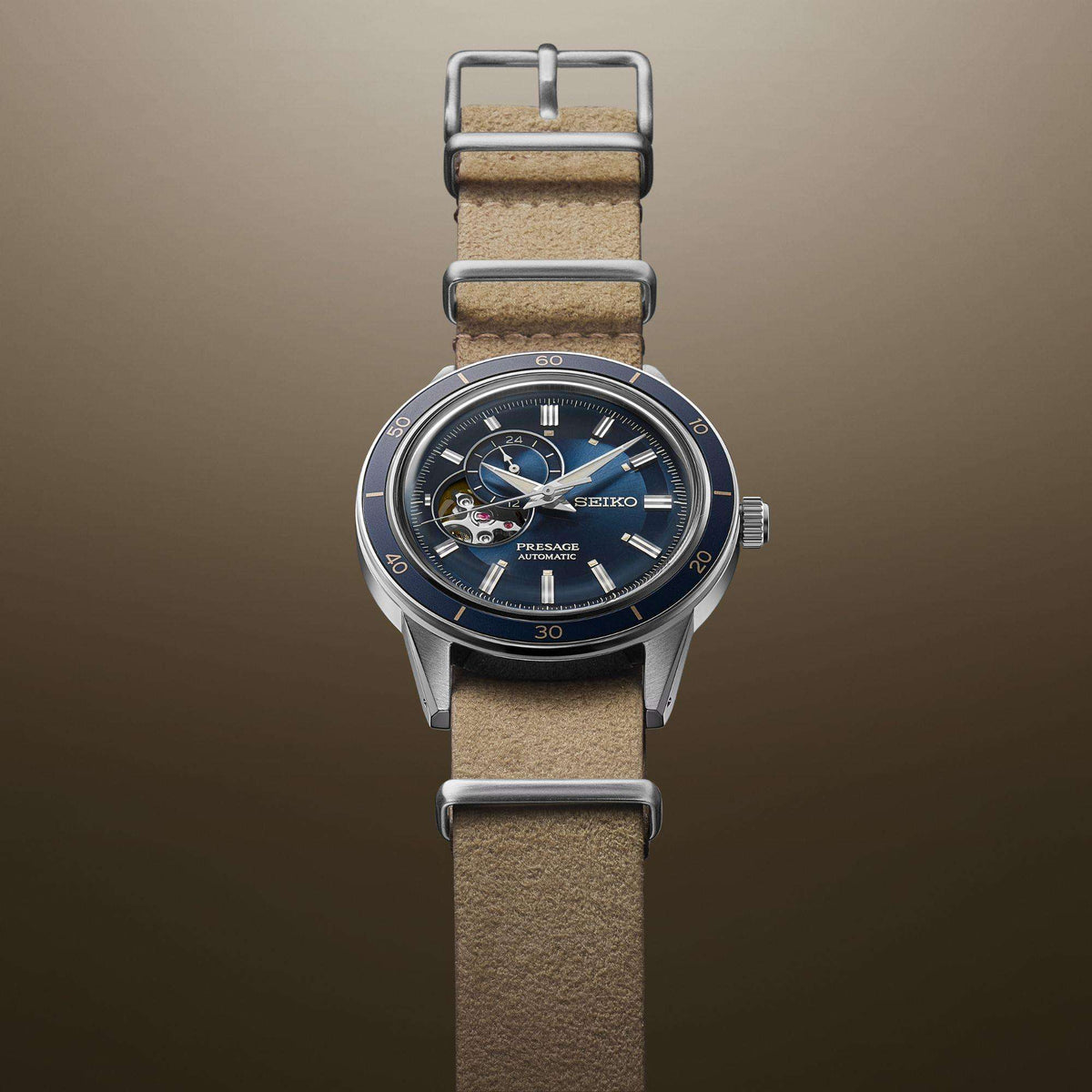 Automatic wristwatch with blue face and beige leather strap; side-mounted crown