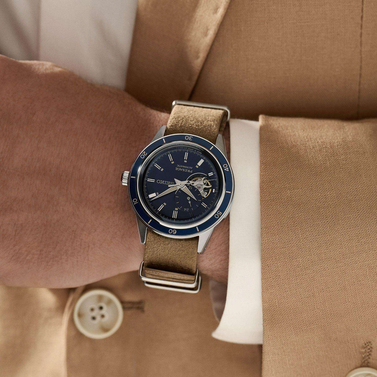 Blue-dial automatic watch on beige leather strap with metal case and bezel
