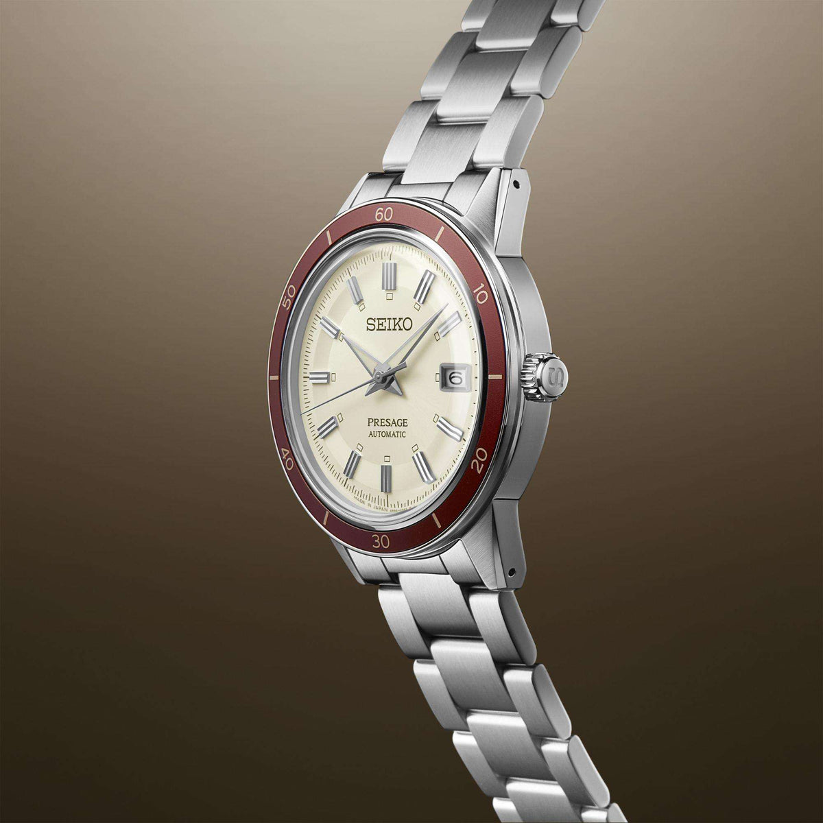 Side view men's stainless automatic wristwatch with white dial, red bezel, steel band