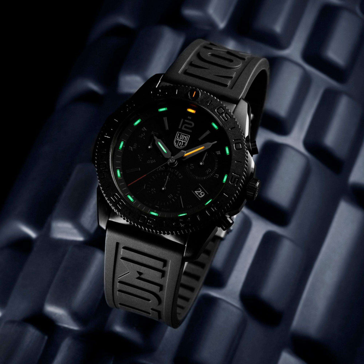 Black diver chronograph watch with glowing green hour markers and subdials