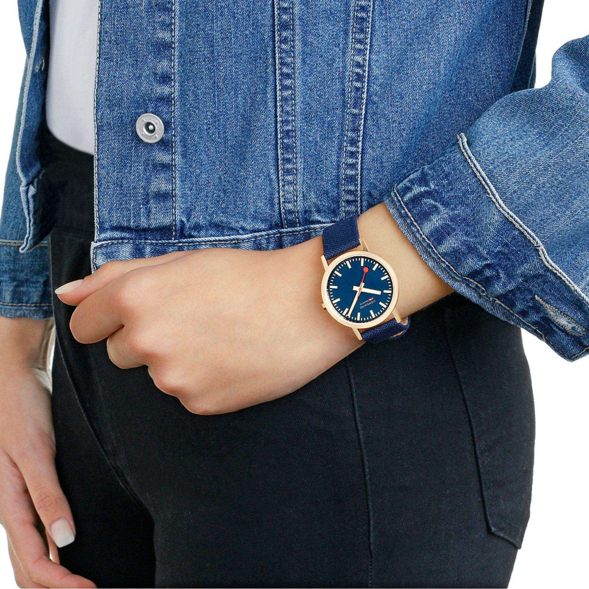 Round gold-tone Mondaine watch with deep blue dial and blue fabric strap