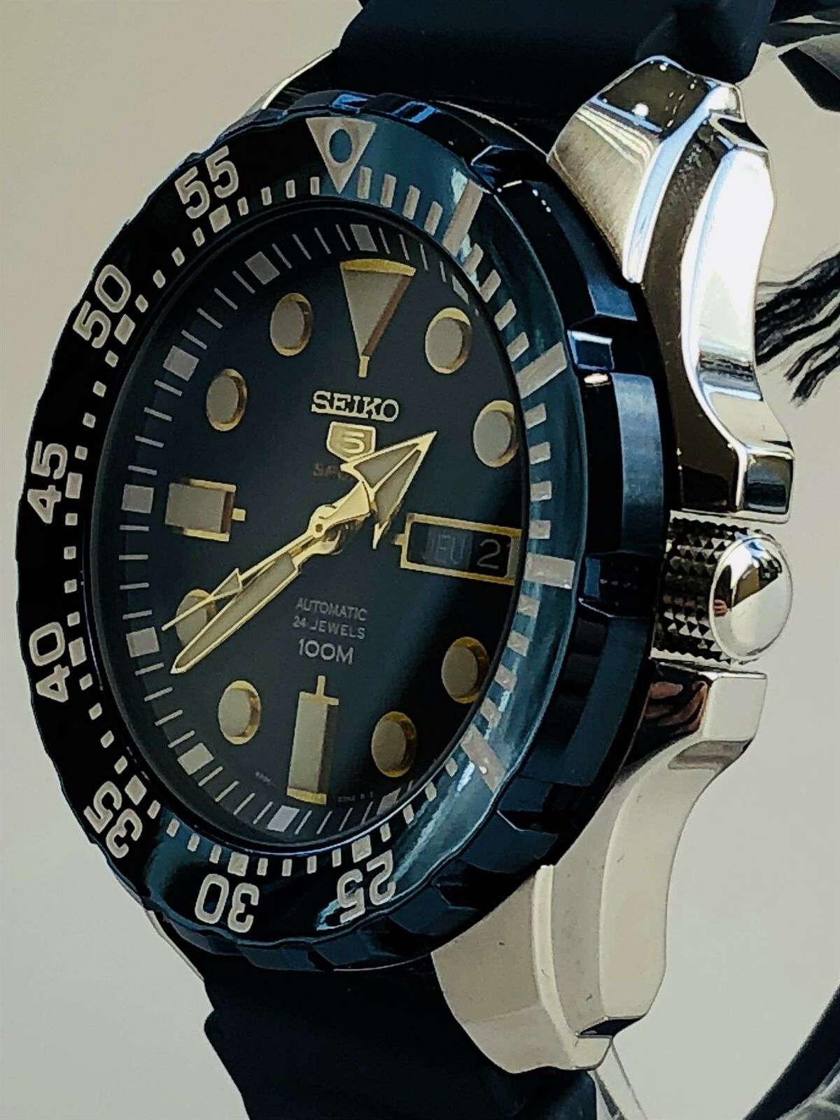 Seiko 5 Sports automatic watch angled view with blue dial, bezel numerals, and crown