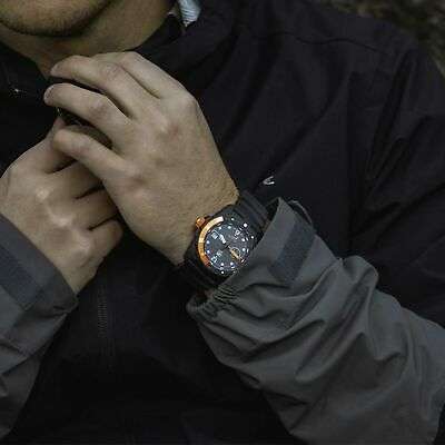 Man wearing a black sports watch with glowing dial and orange accents