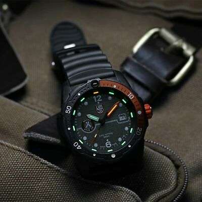 Black rubber men’s dive watch on fabric, orange side accent and glow-style dial markers.