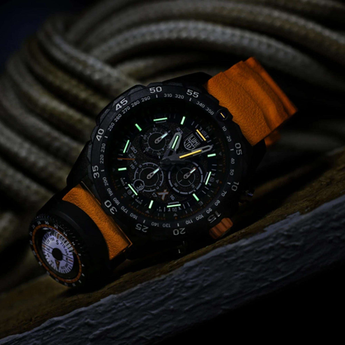 Angled dark view of the Luminox Bear Grylls XB.3749 showing green tritium night sight illumination on hands and markers