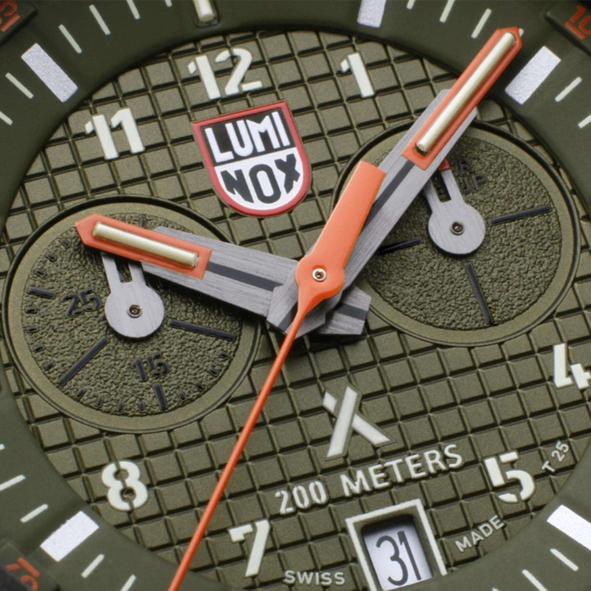 Men's survival watch dial close-up with LUMINOX logo and orange hands on green face