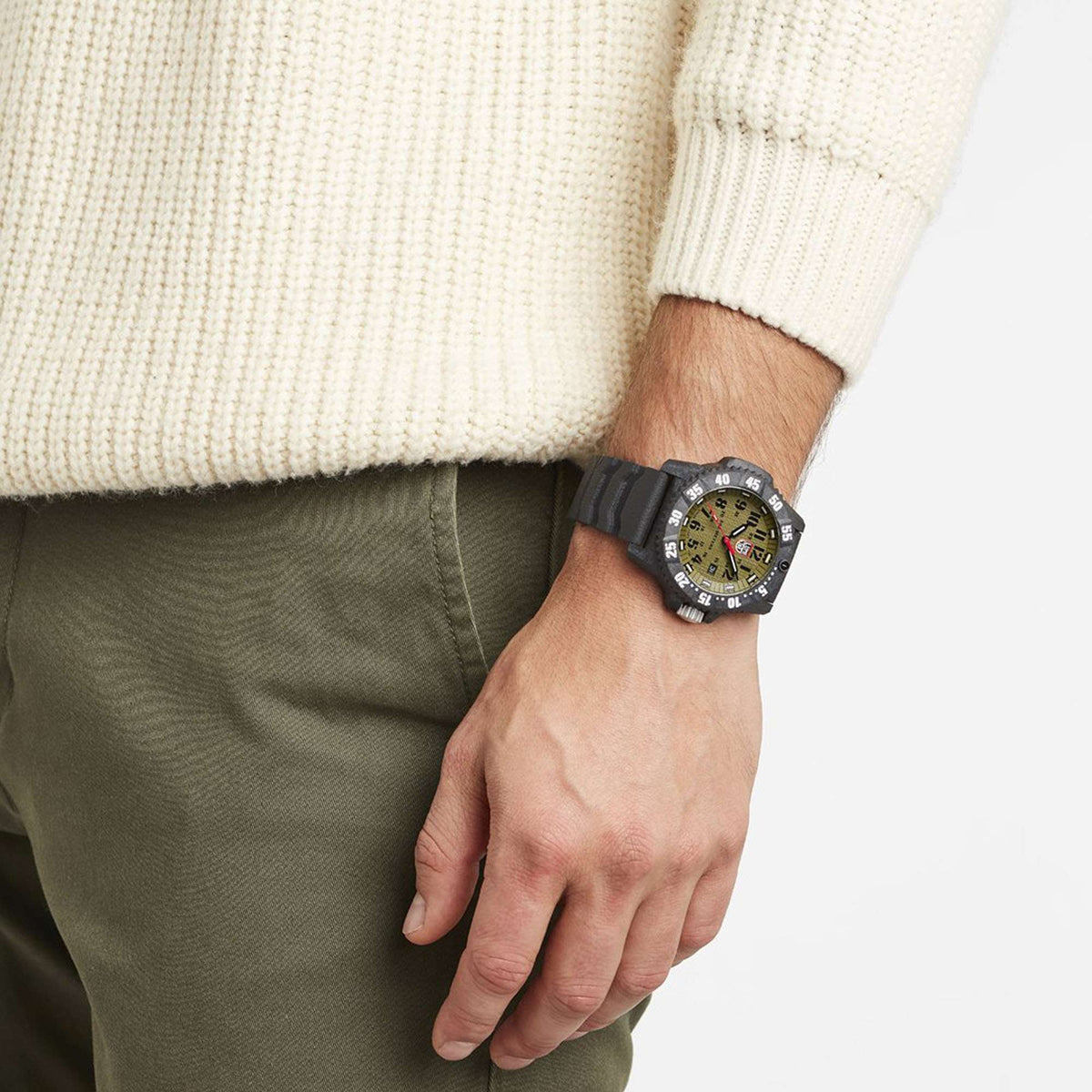 Men's quartz wristwatch on wrist with green dial, black rubber strap, dark bezel and markers
