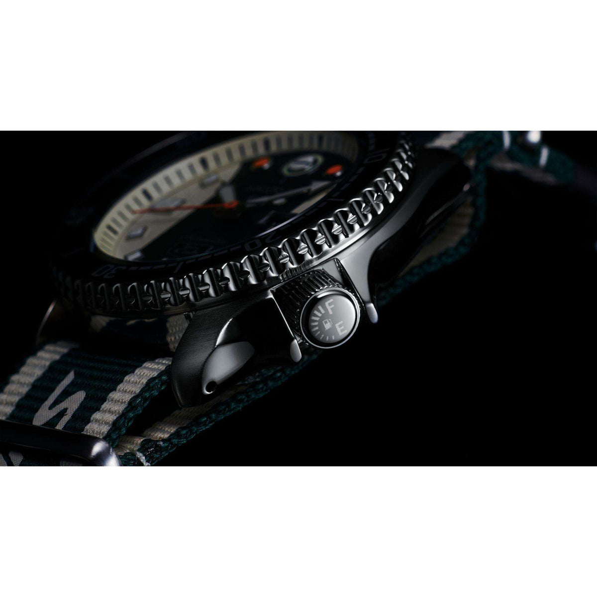 Stainless watch case with crown and textured bezel detail on striped fabric strap
