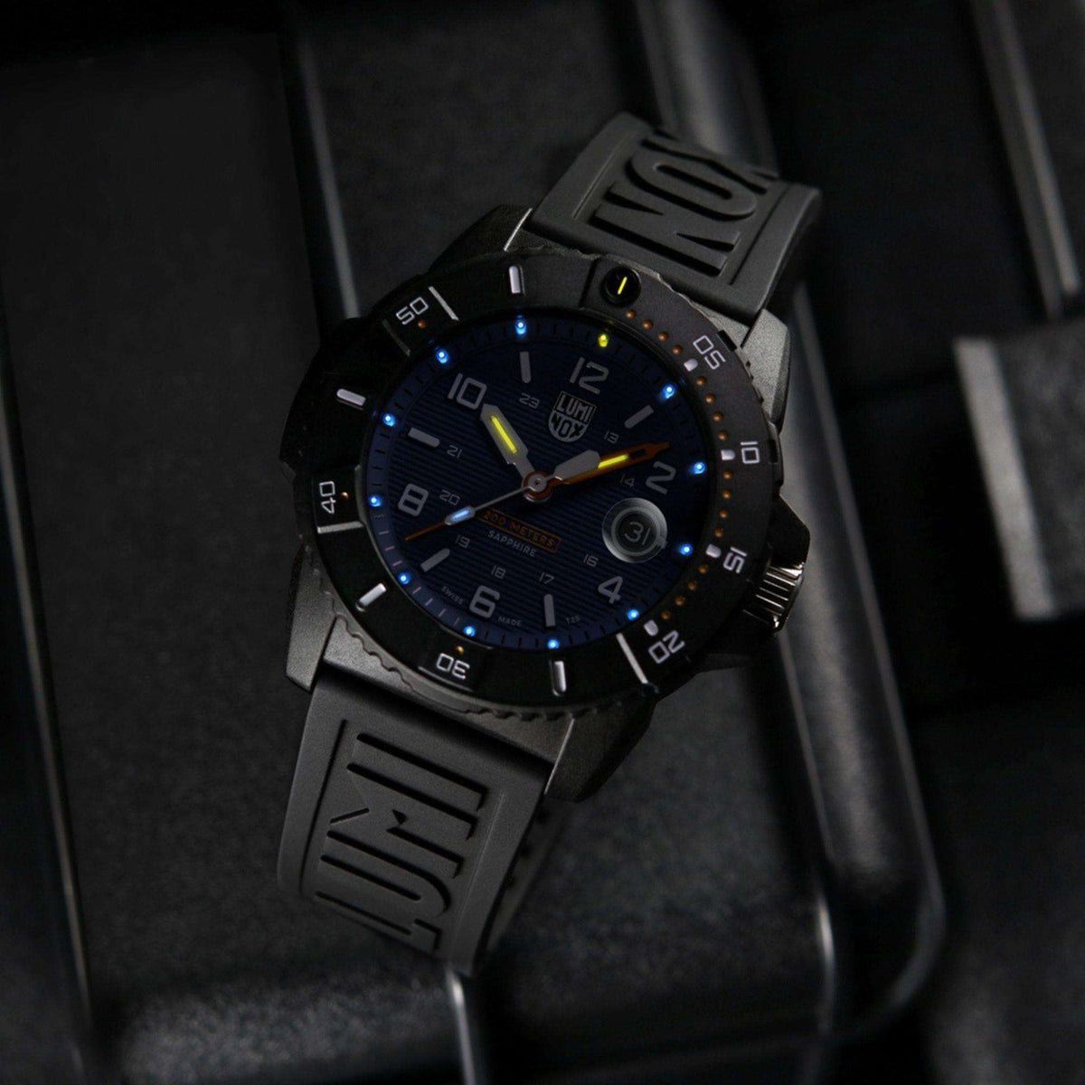 Men's Luminox dive watch with glowing blue dial, black silicone strap, luminous markers
