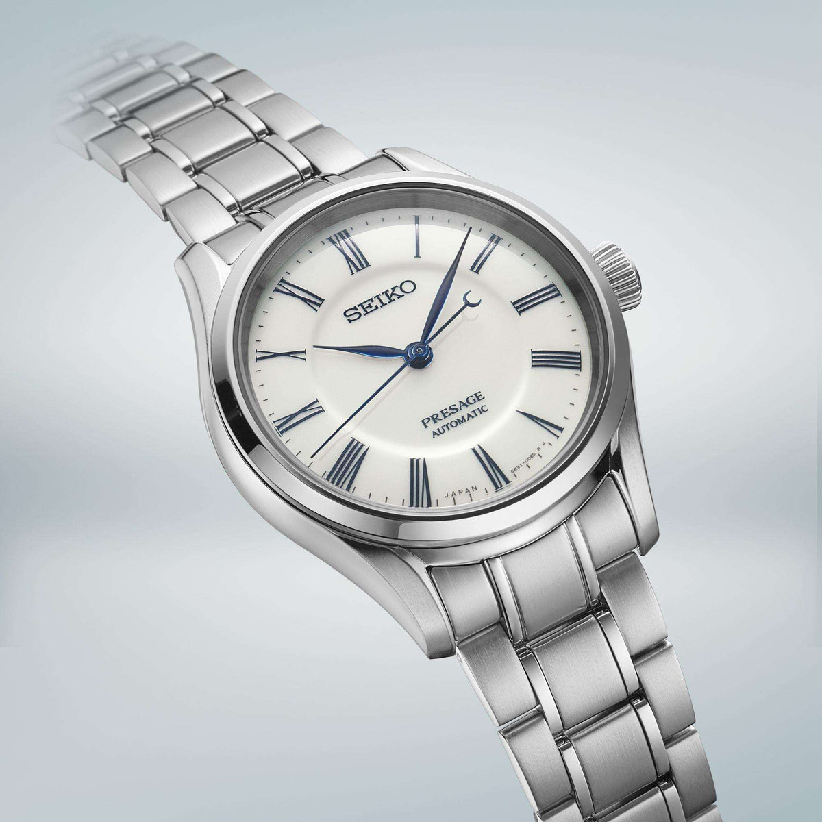 Angled men's stainless steel wristwatch with white dial, blue hands, linked bracelet
