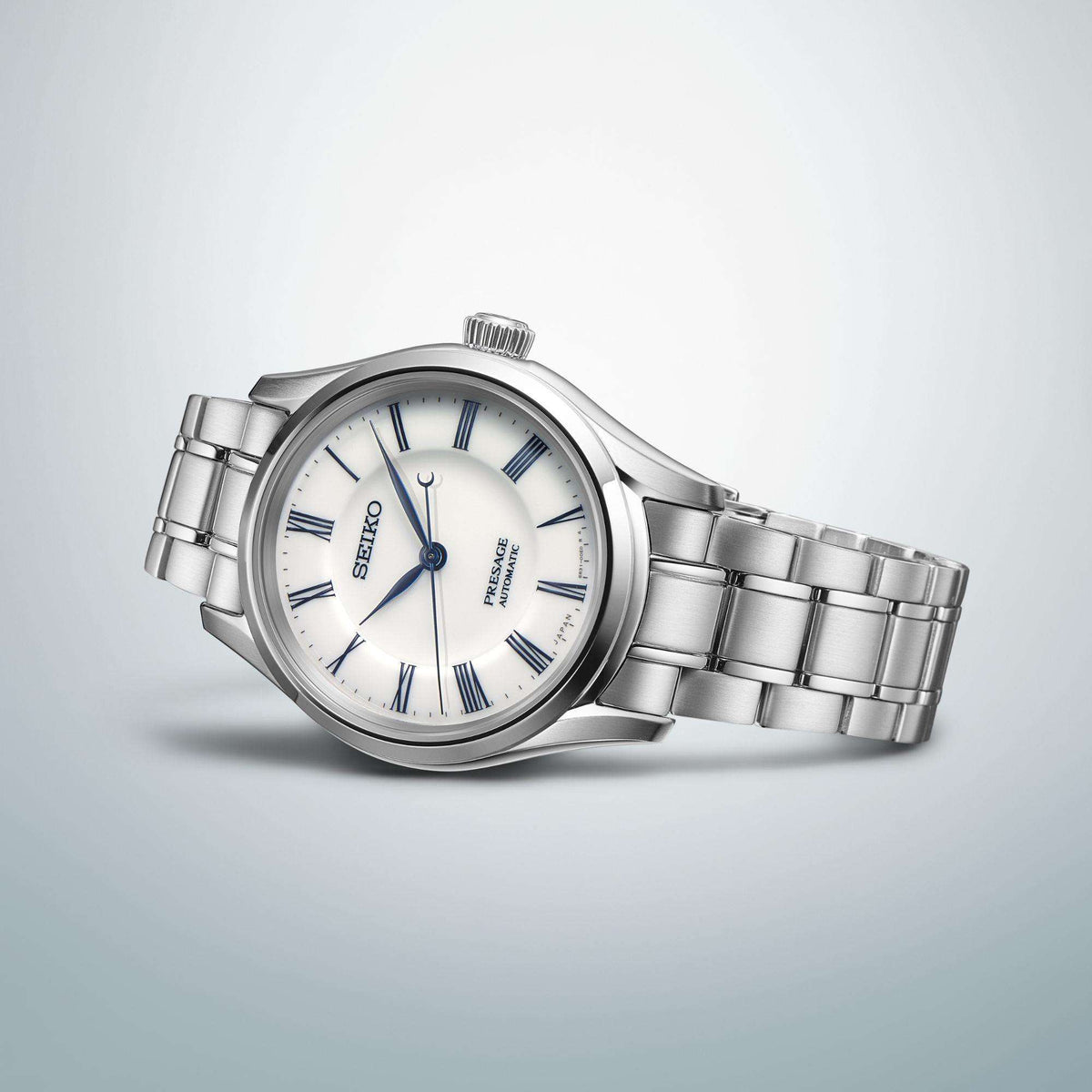Men's stainless steel wristwatch side view with white dial and blue accents on bracelet