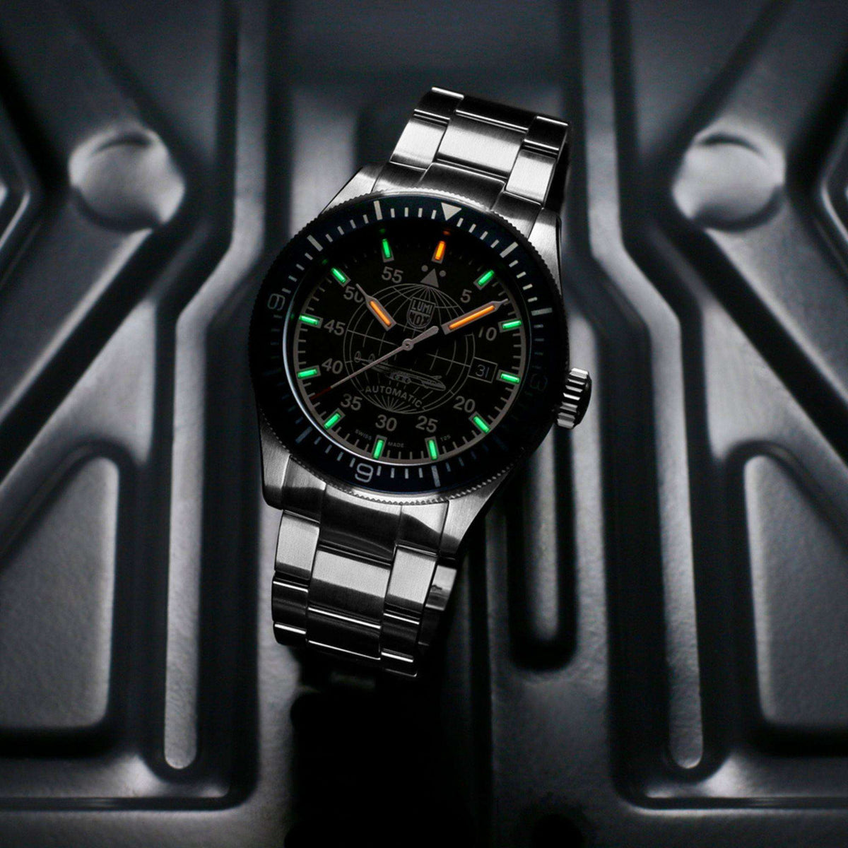 Luminox Constellation 9600 Series XA.9601.M low light view of illuminated hands and hour markers on black dial with steel bracelet