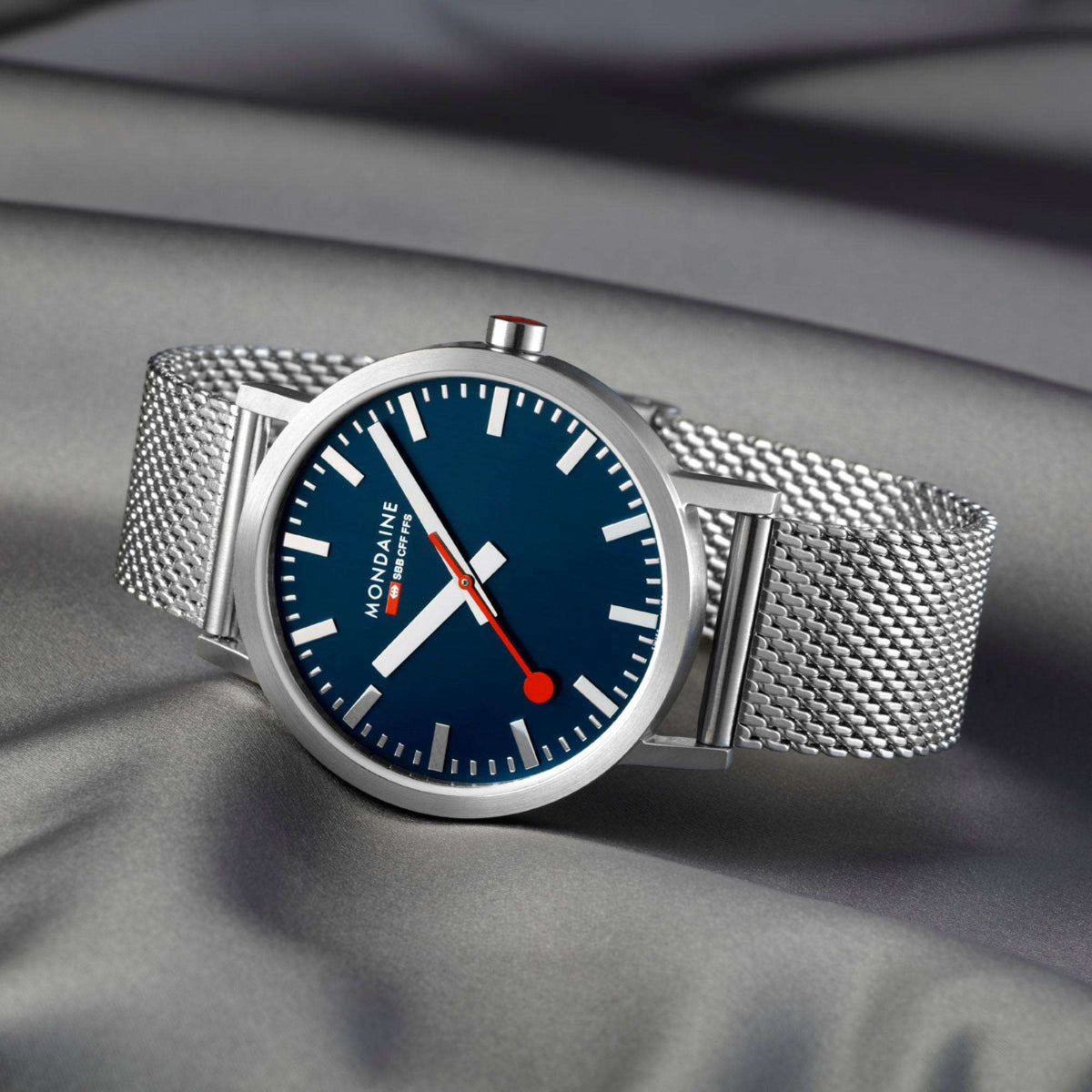 Mondaine blue dial steel mesh watch with red second hand, close three-quarter angle