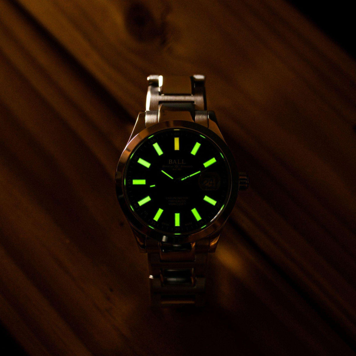 Men's wrist watch with dark green dial and stainless steel link bracelet, luminous hour marks.