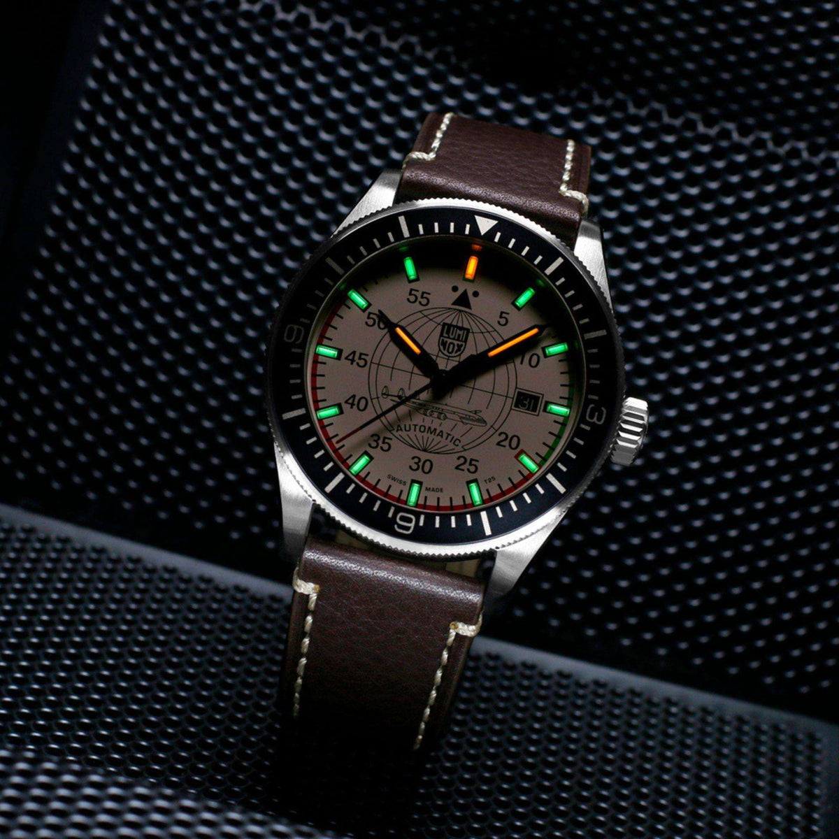 Luminox Constellation XA.9607 angled low light view displaying illuminated gas tubes on cream dial with brown leather strap