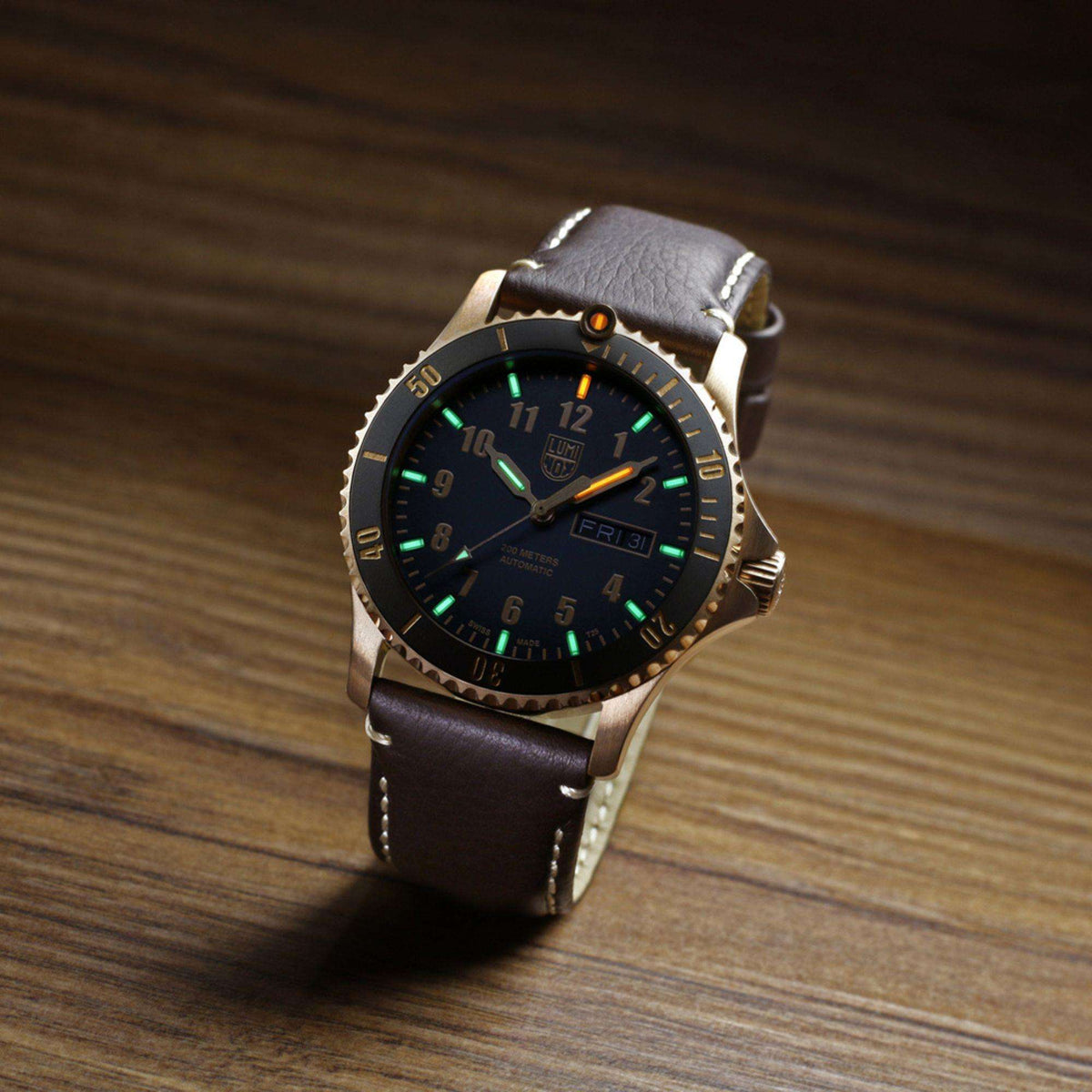 Men's automatic watch with black dial, green markers, gold bezel, brown leather strap