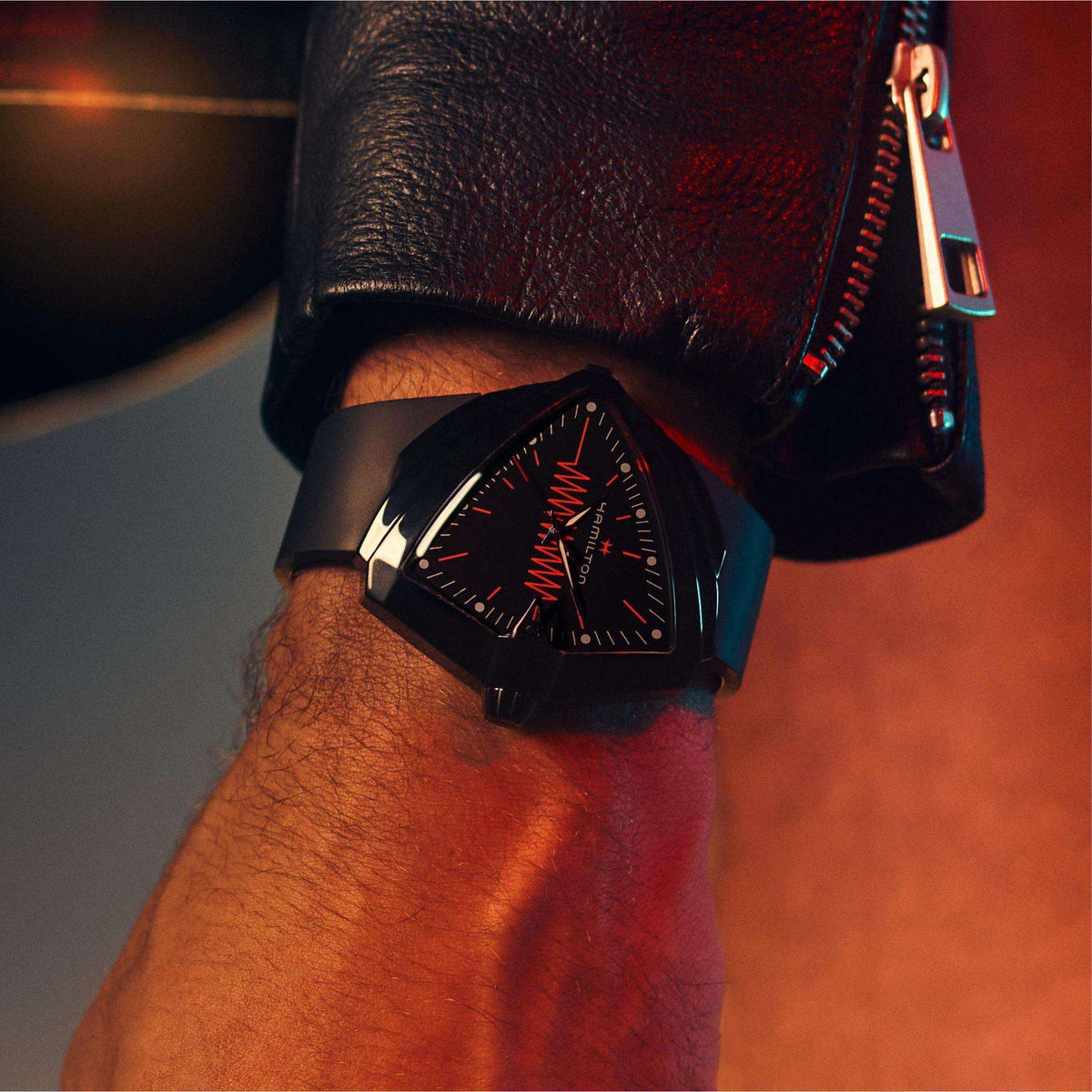 Close-up of a men's black strap quartz watch on wrist, black dial with red accents