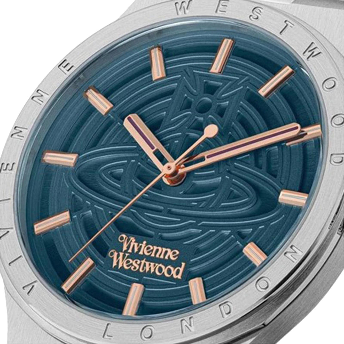 Women's watch dial close-up with dark blue embossed pattern, rose-gold hour markers.