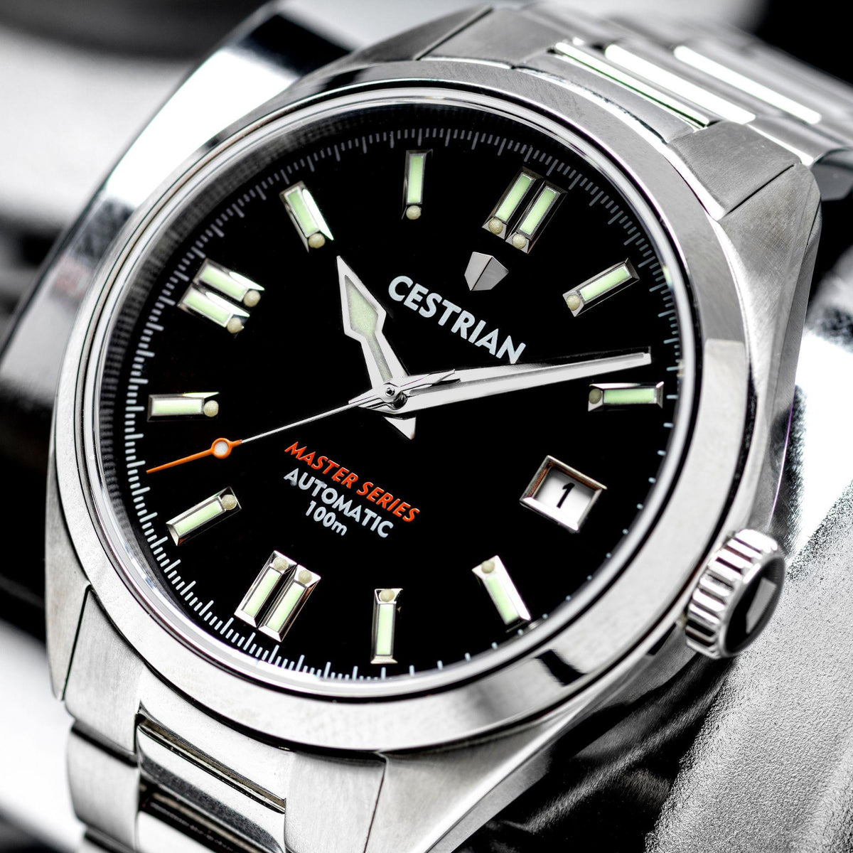 Automatic men’s watch close-up: black dial, luminous hands and markers, steel bracelet