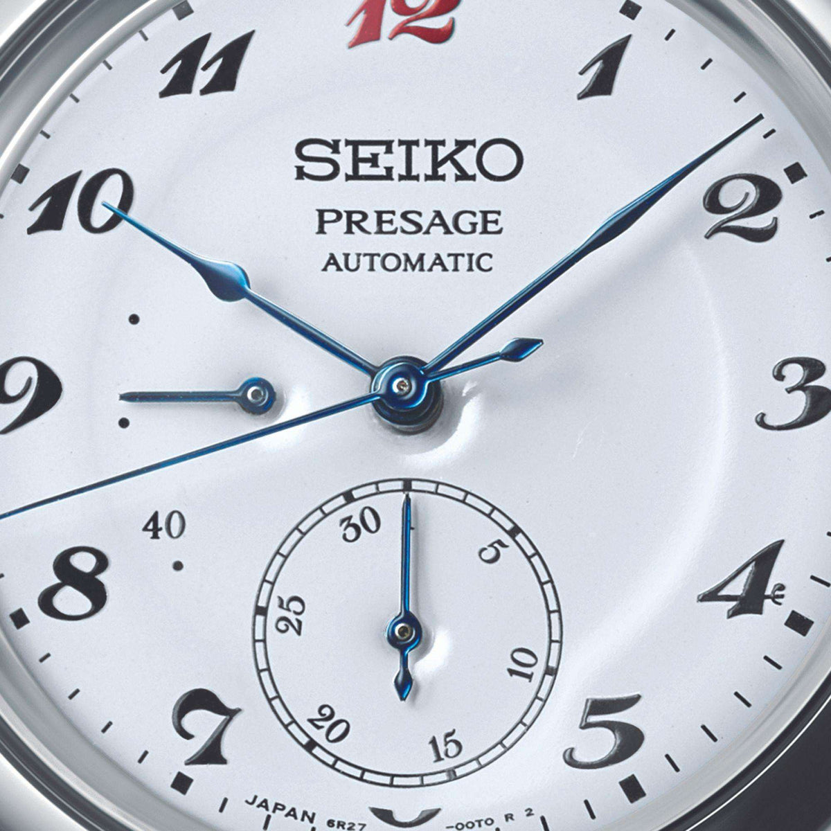 Close-up shot of the white dial focusing on the blue hands, power reserve indicator, and the date sub-dial at 6 o'clock.