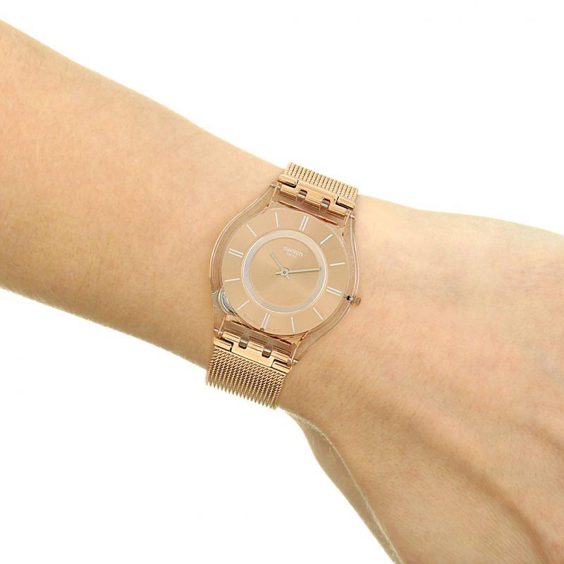 Rose-gold quartz watch on wrist with mesh bracelet and rose dial, analog time display