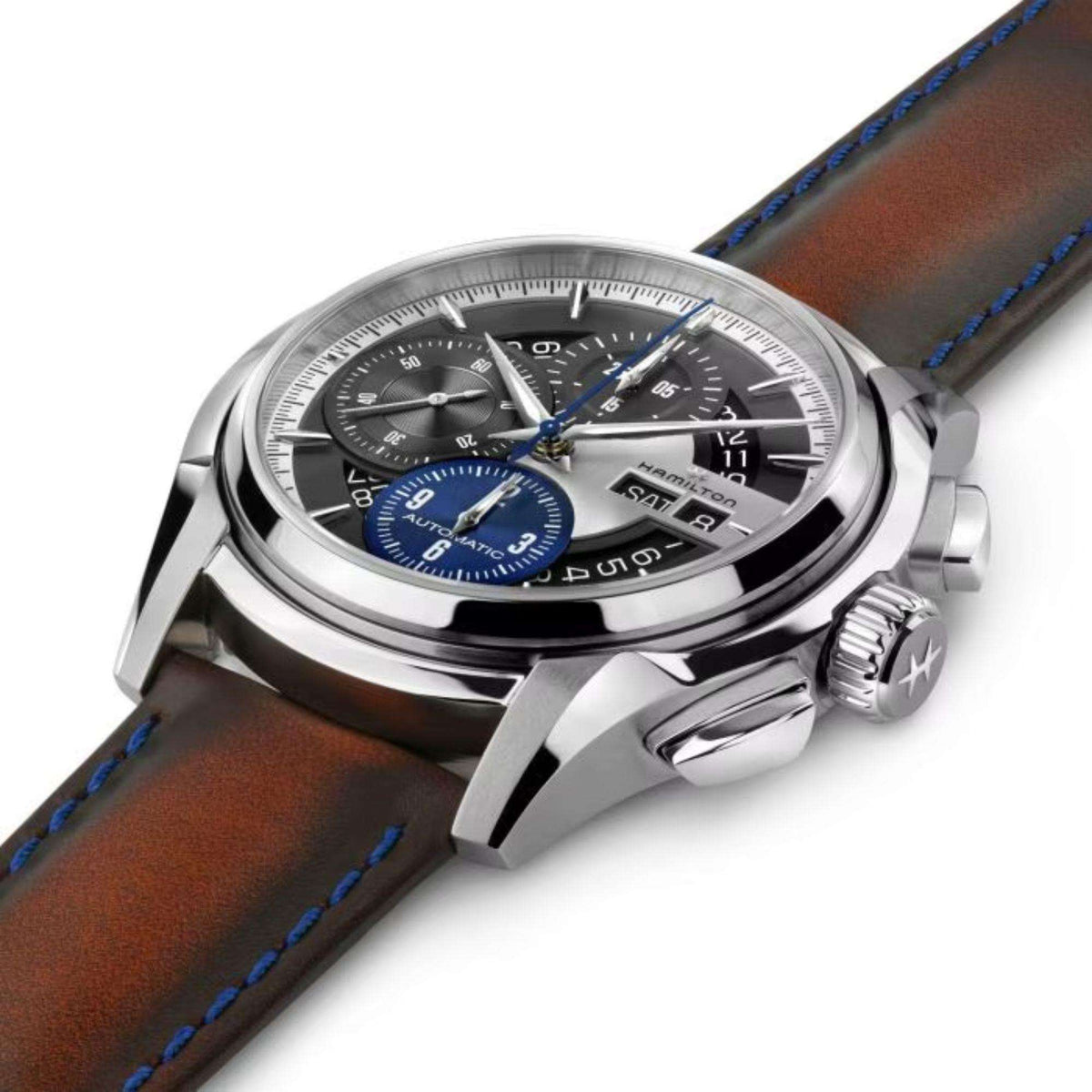 Men's silver automatic wristwatch side angle with brown leather strap and blue dial accents