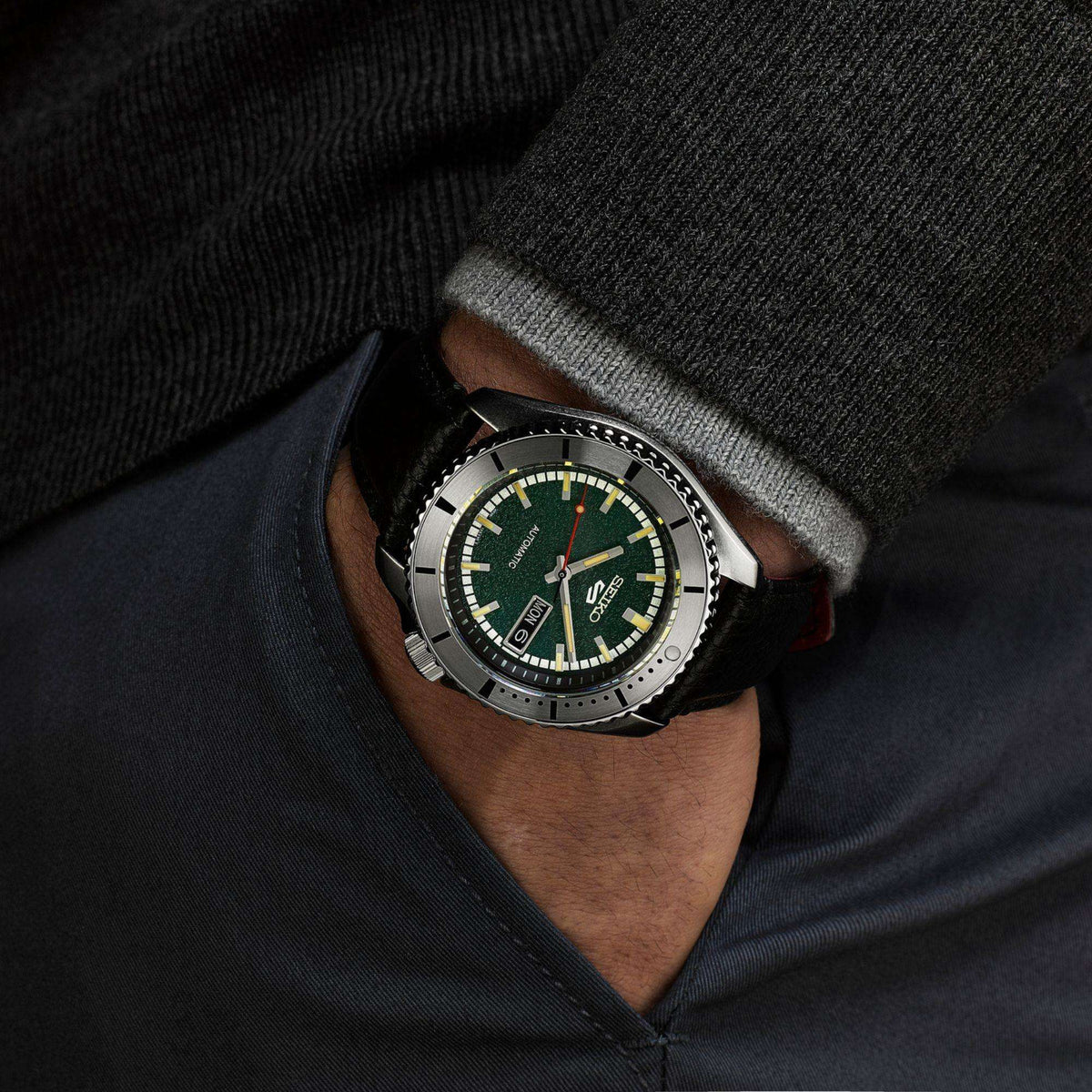 Close-up of a wrist wearing Seiko 5 Sports x Masked Rider Watch SRPJ91K1 with black strap.