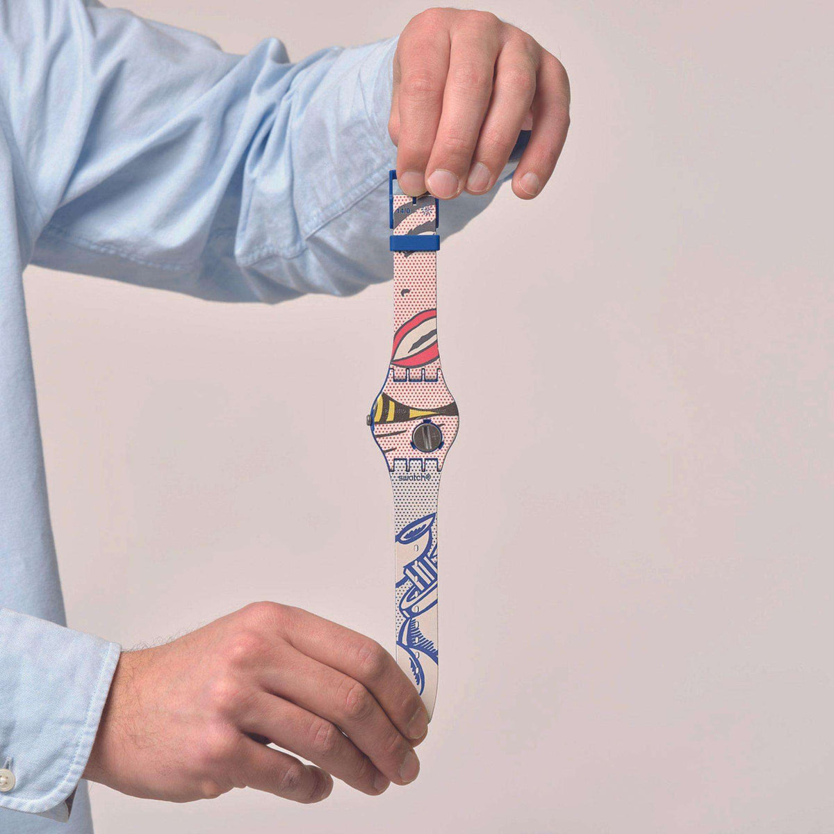 Blue silicone strap Swatch wristwatch with pop-art girl dial, worn on wrist