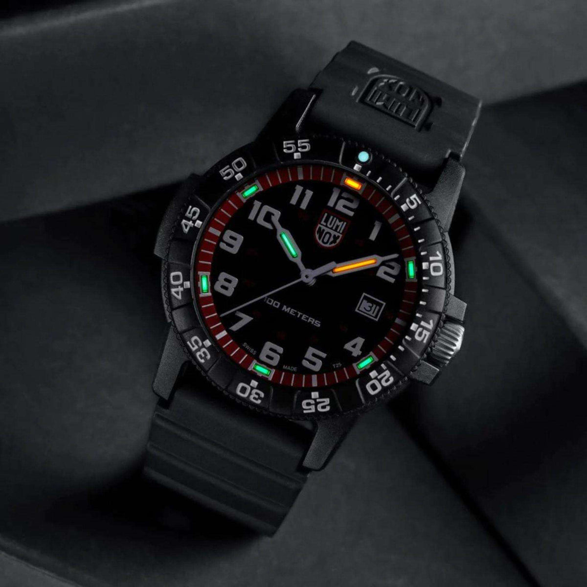 Black rubber strap quartz diver watch angled view with glowing orange and green hands