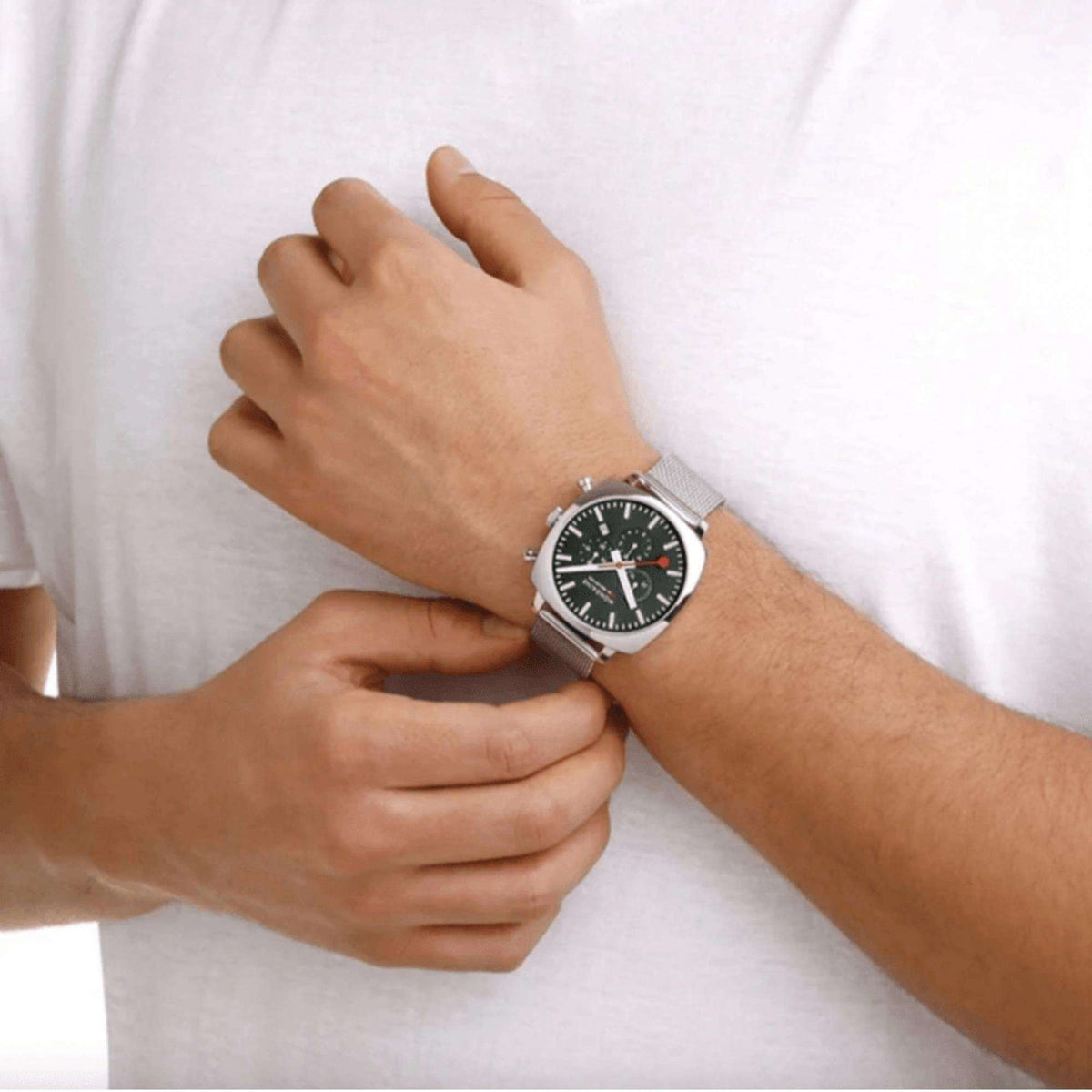 Men's chronograph watch on wrist with green dial and green textile strap