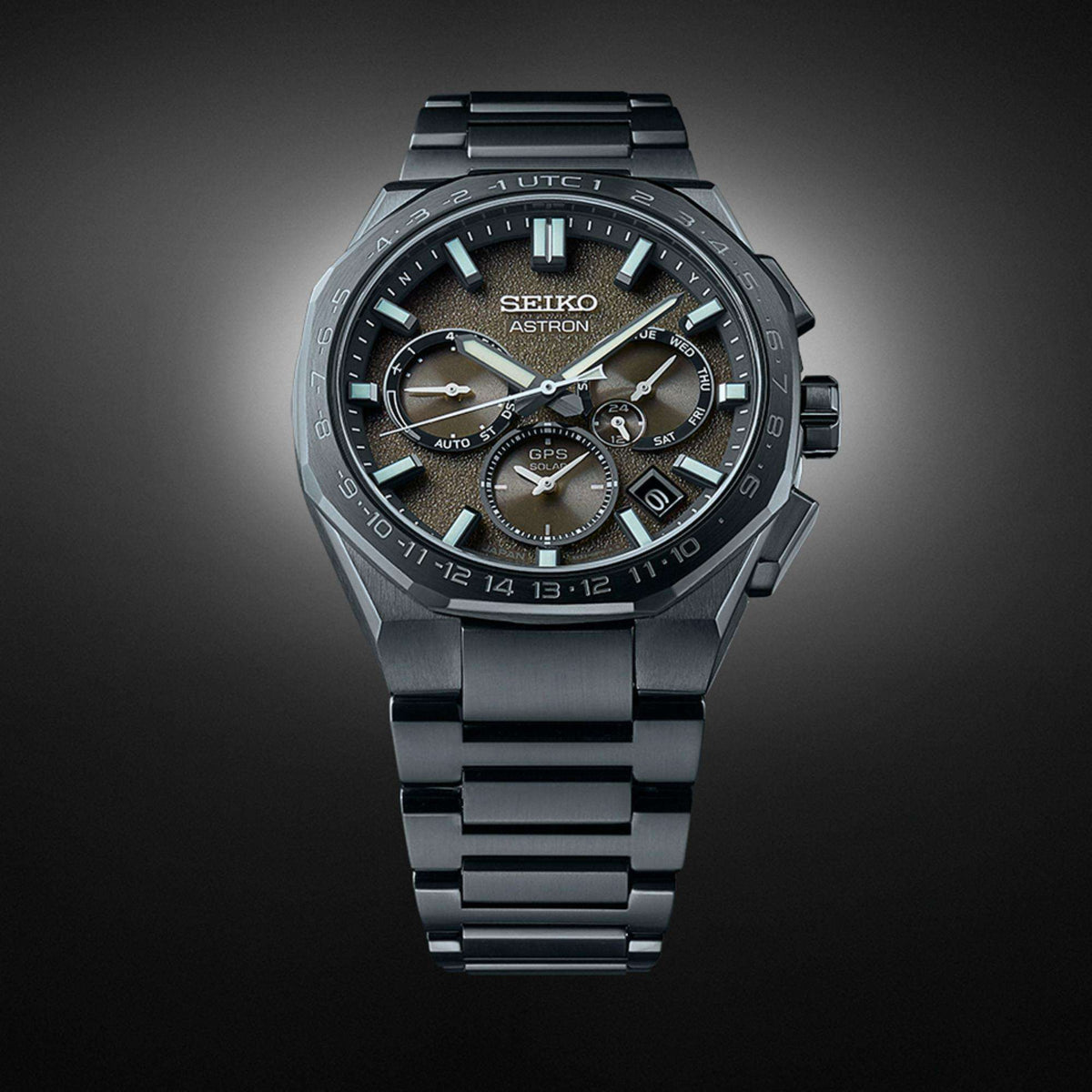 Front view of the black titanium watch standing vertically against a dark background