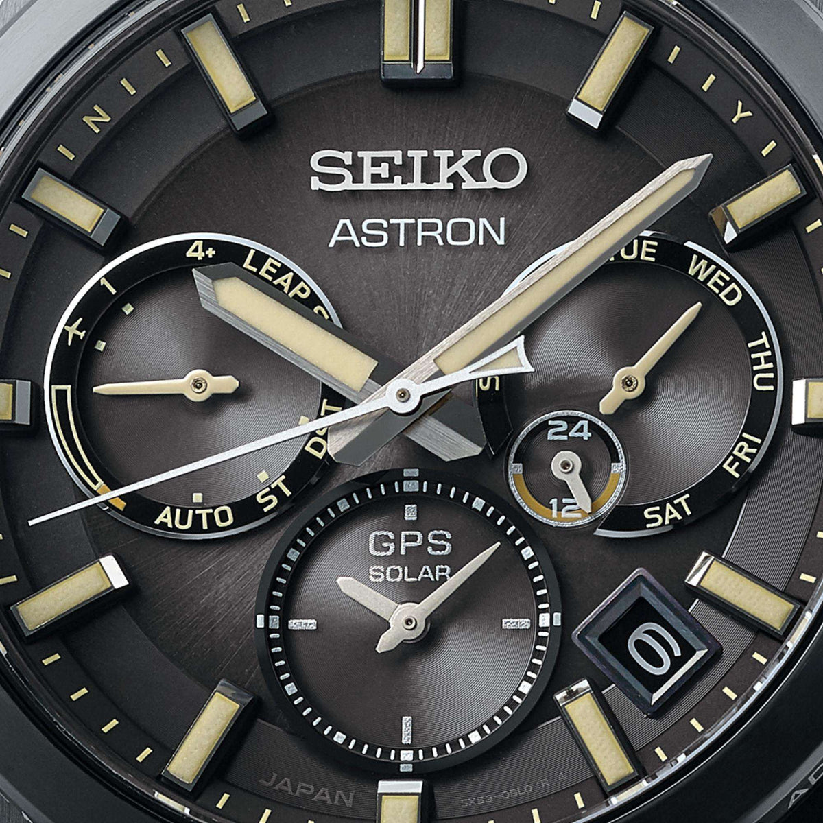 Macro close-up of the black dial, highlighting the luminescent hands, markers, and three chronological sub-dials including a GPS solar indicator.