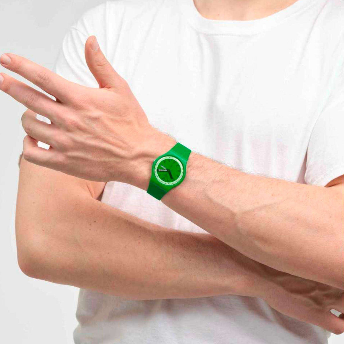 Green quartz wristwatch worn on forearm with green silicone strap