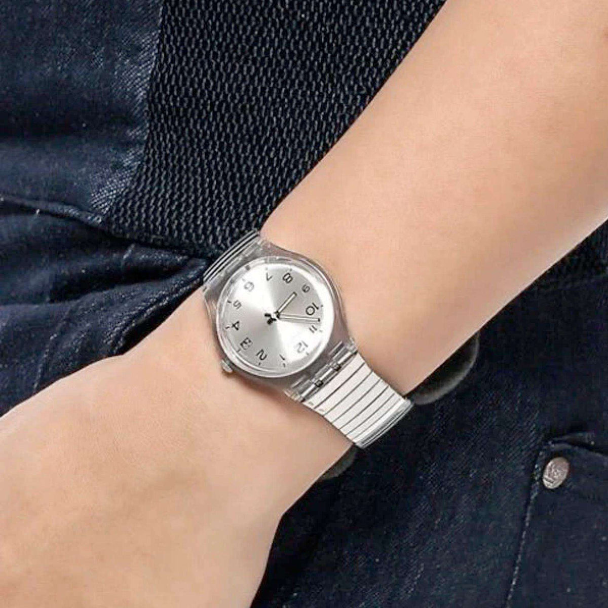 Swatch quartz watch close-up on wrist, silver-tone metal band and white dial