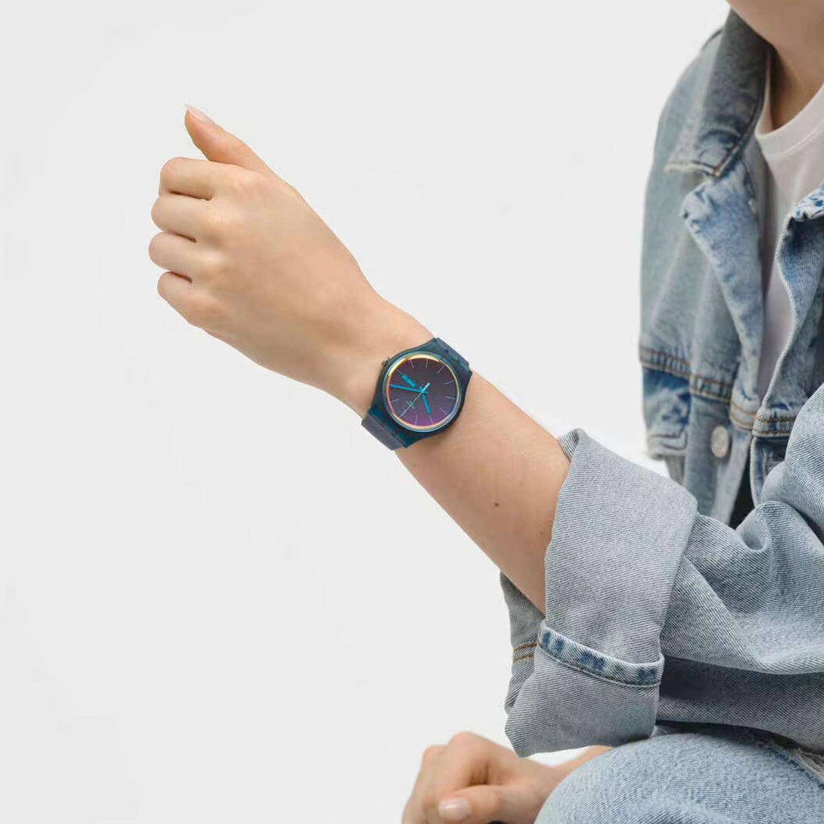 Ladies quartz watch on wrist with dark teal silicone strap and gradient blue dial