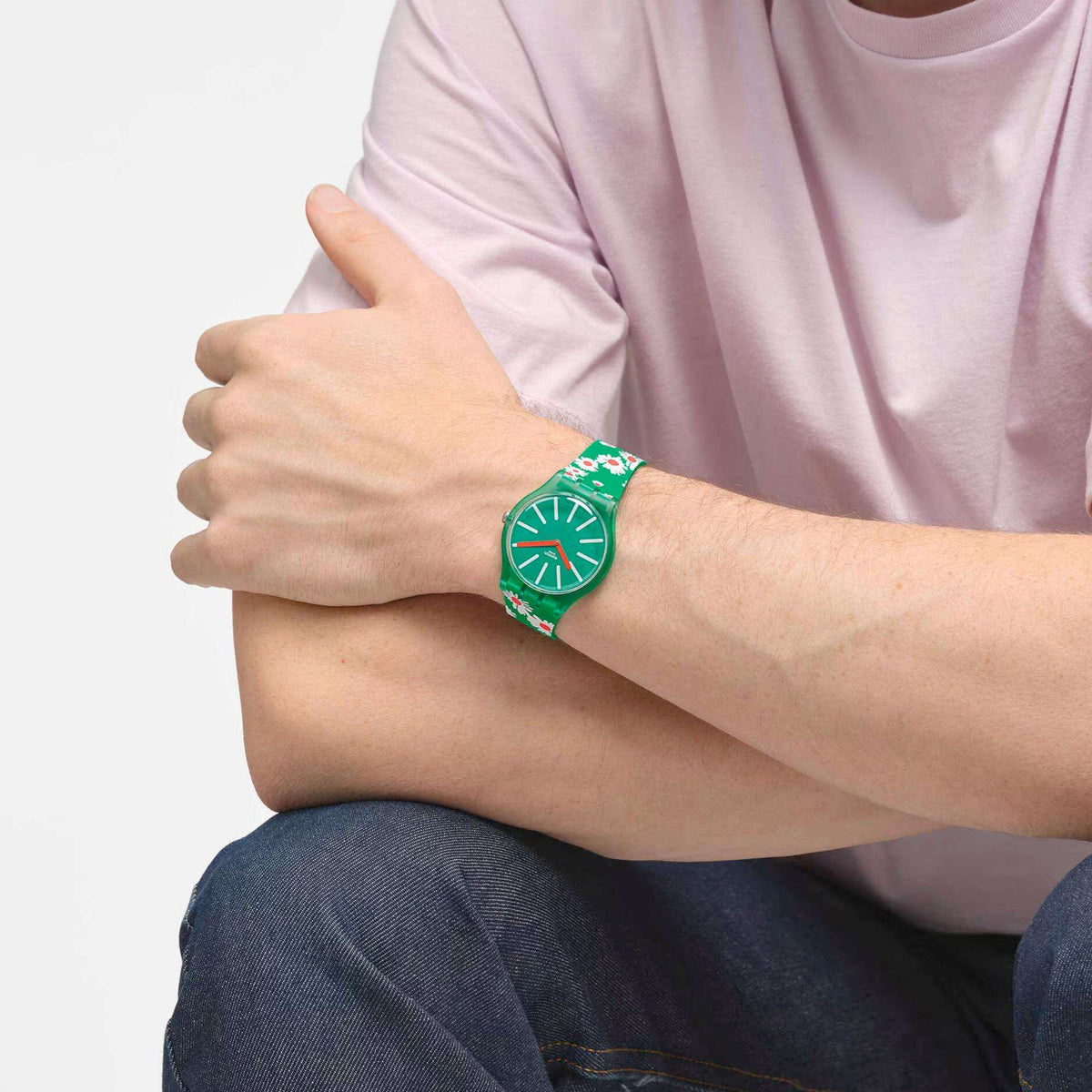 Green floral quartz watch on wrist with white markers and orange hands, round green face