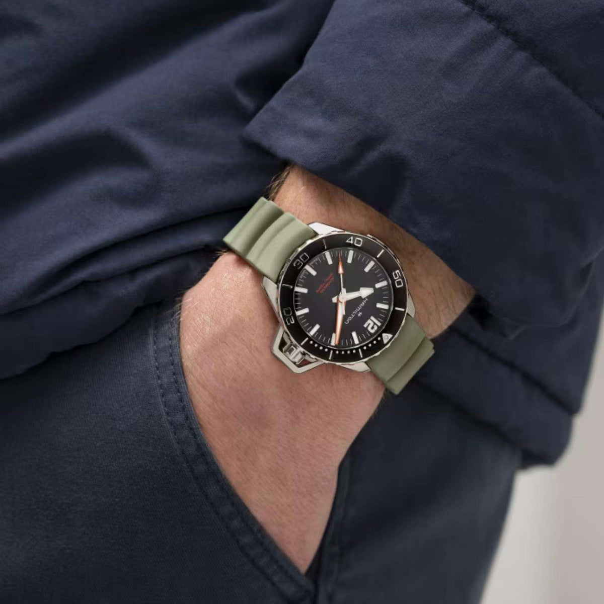Hamilton automatic watch on wrist with dark green rubber strap and black dial
