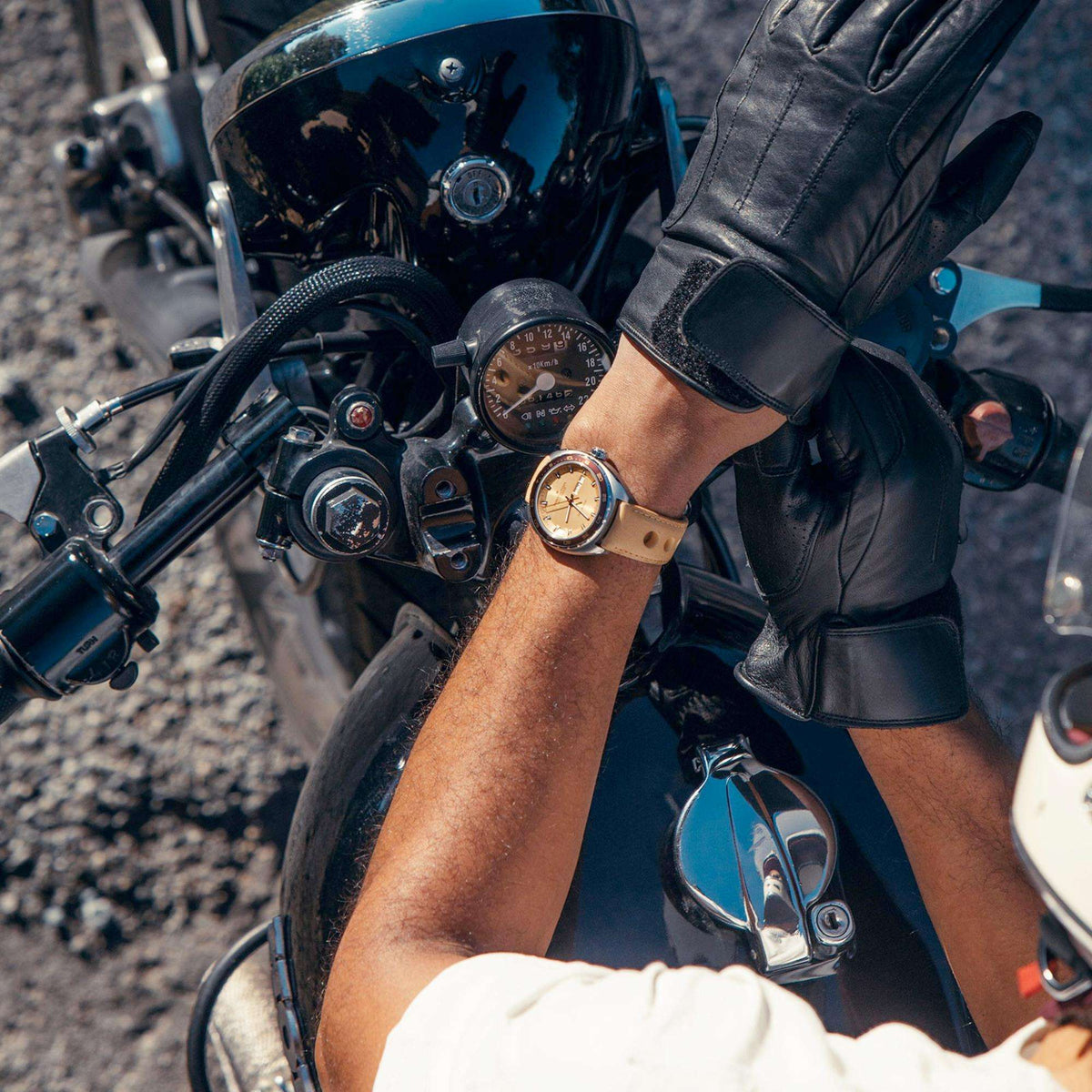 Men’s automatic watch on wrist with brown leather strap on a motorcycle