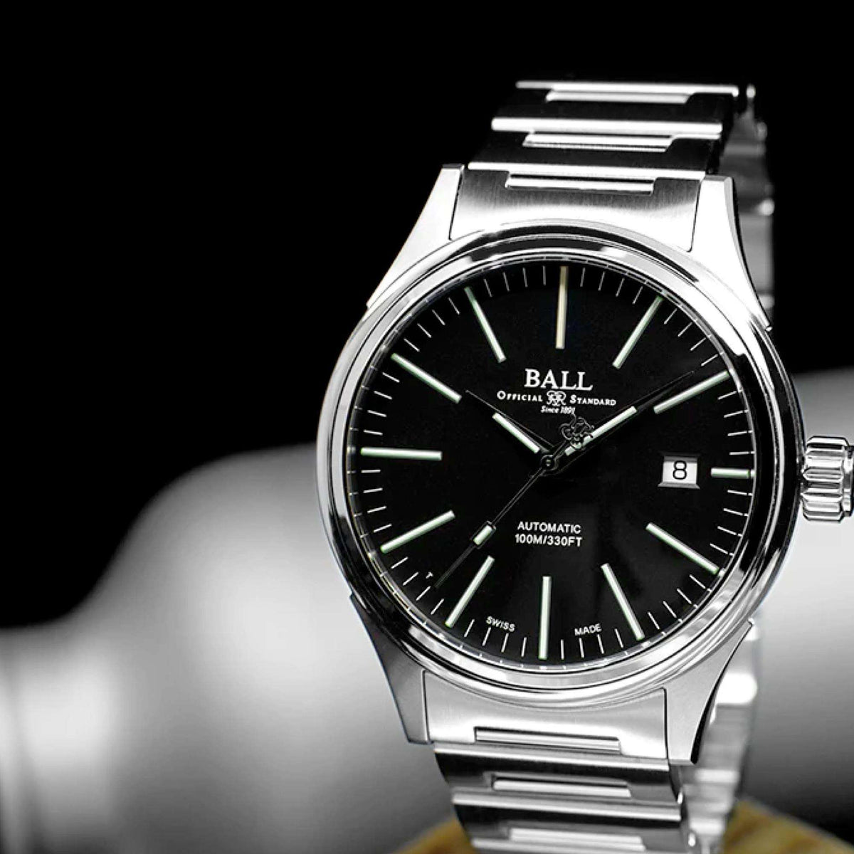 Automatic wristwatch with black dial, green indices, and polished steel case, crown side