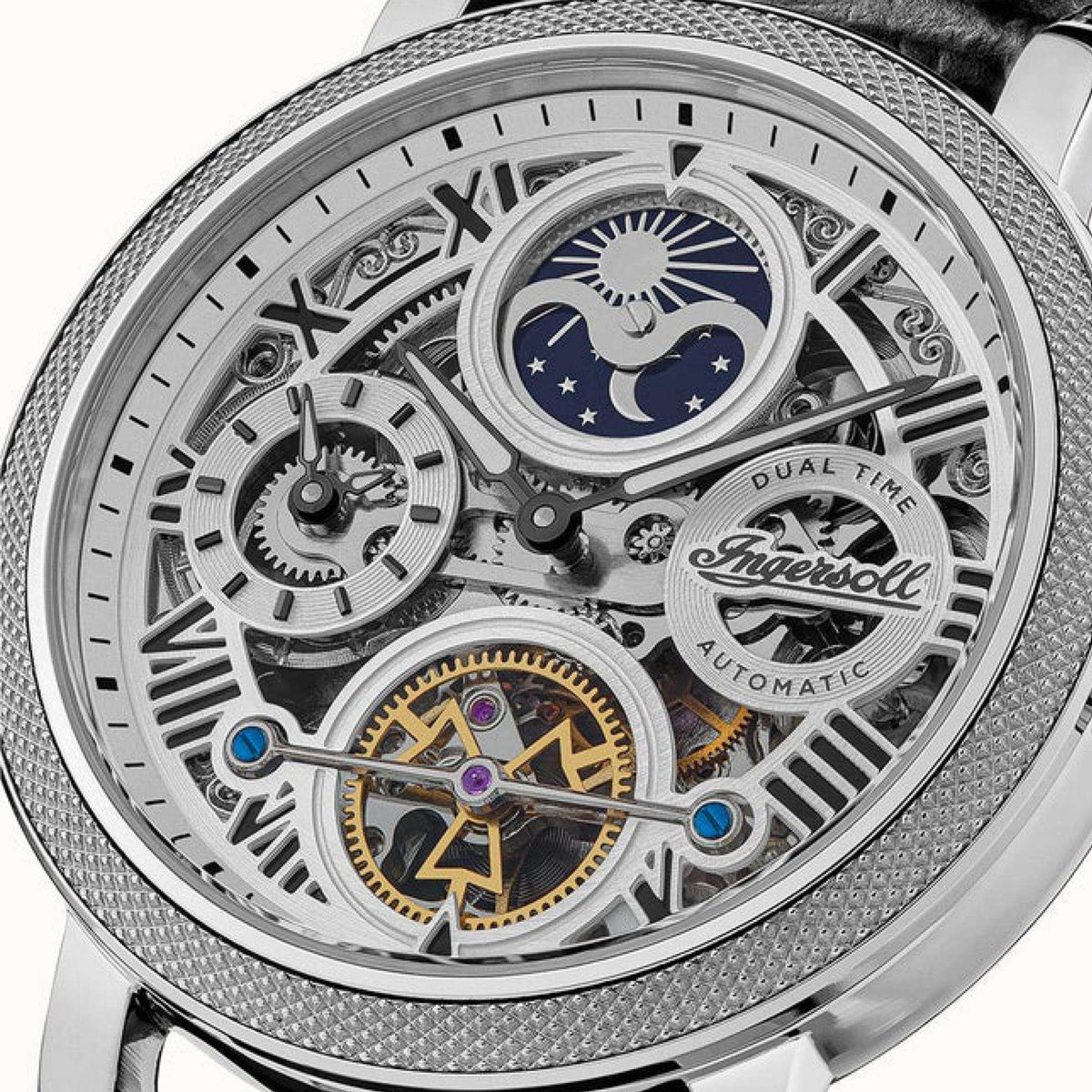 Close-up of men's open-heart skeleton dial with gold and blue accents, silver textured bezel