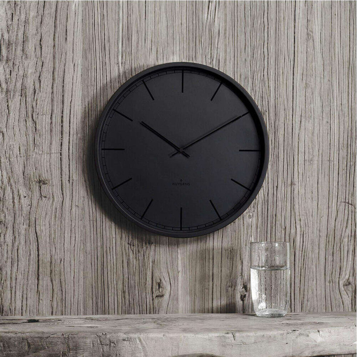 Black round wall clock with minimal index markers and three hands