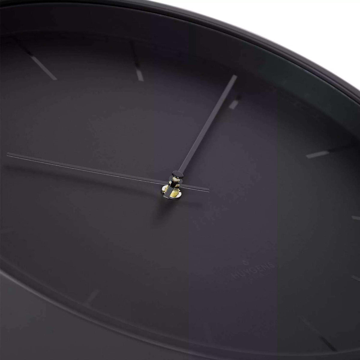 Close-up of black clock hands and central dial hub with slim index markers