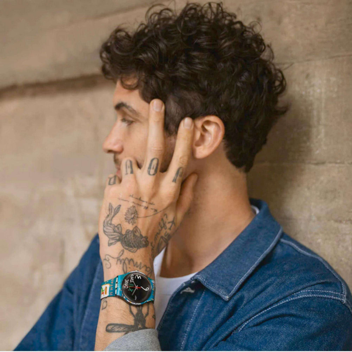 Quartz wristwatch on wrist with teal graphic band and round black dial