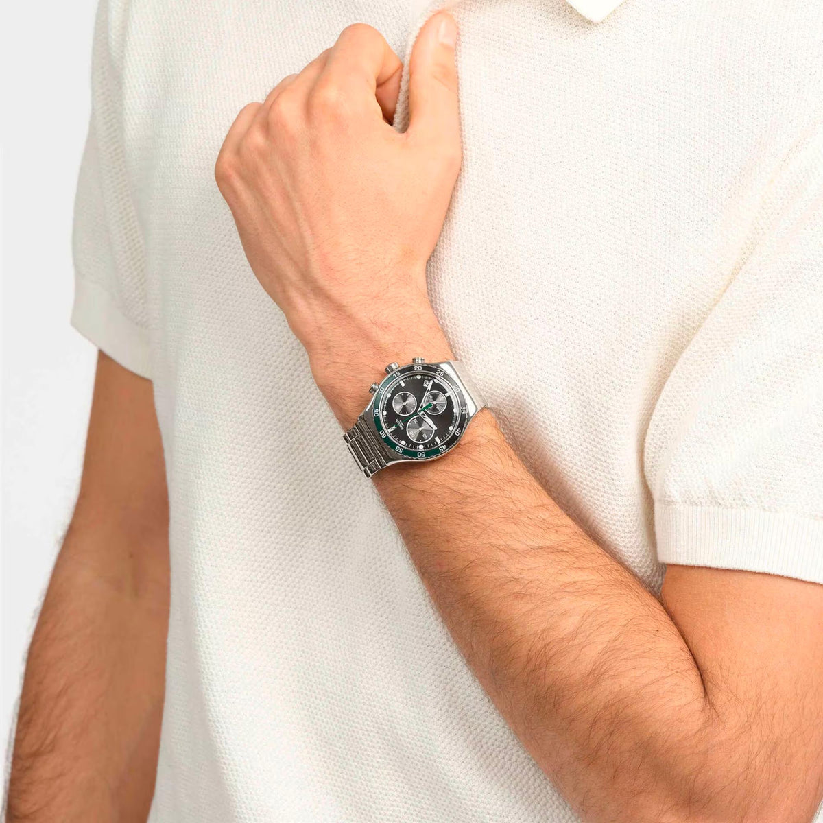 Stainless steel wristwatch on wrist with dark dial and green-accent bezel