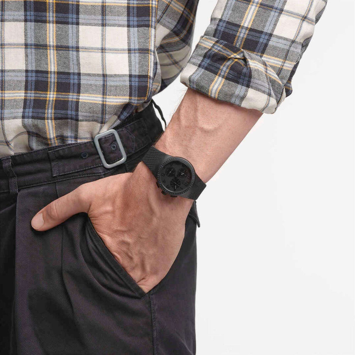 Men's black Swatch wristwatch with dark dial and textured silicone band on wrist