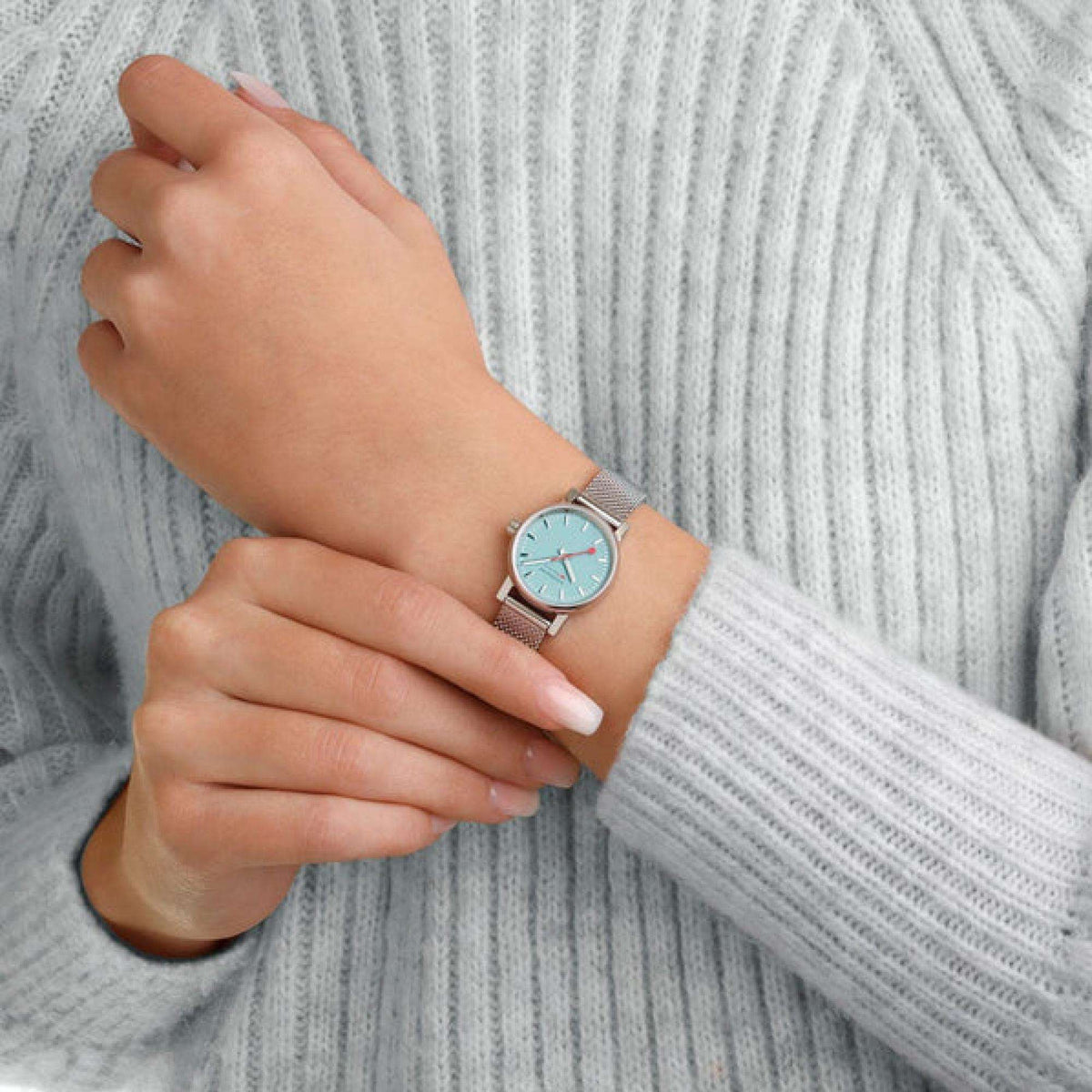 Ladies watch on wrist with light blue dial and silver mesh stainless band