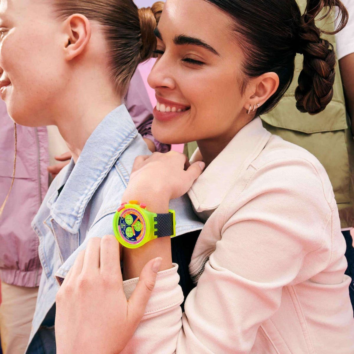 Neon Swatch watch worn on wrist, bright green bezel and multicolor chronograph dial.